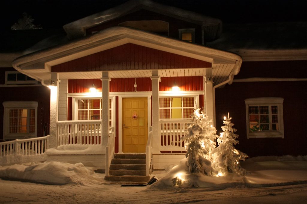 Verschneiter Hauseingang einer Blockhütte in Finnland